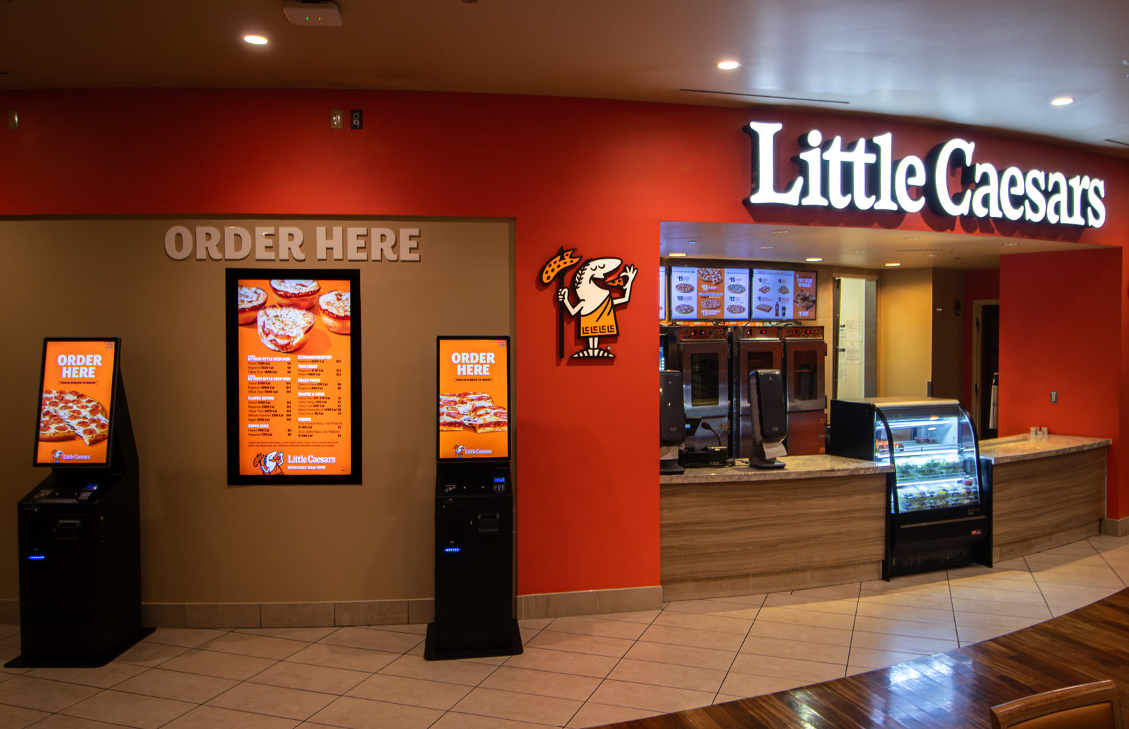Little Caesars restaurant entrance with ordering kiosks and pickup counter