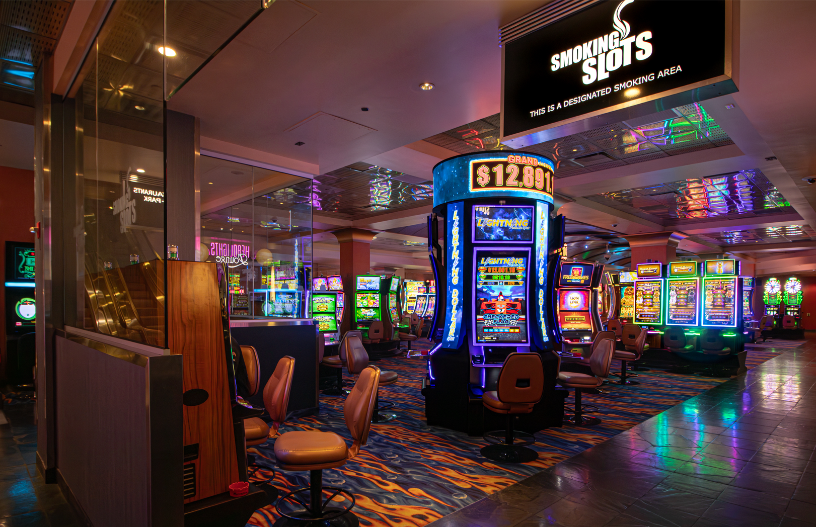 Glass-enclosed smoking slots area with video slot machines at MotorCity Casino Hotel