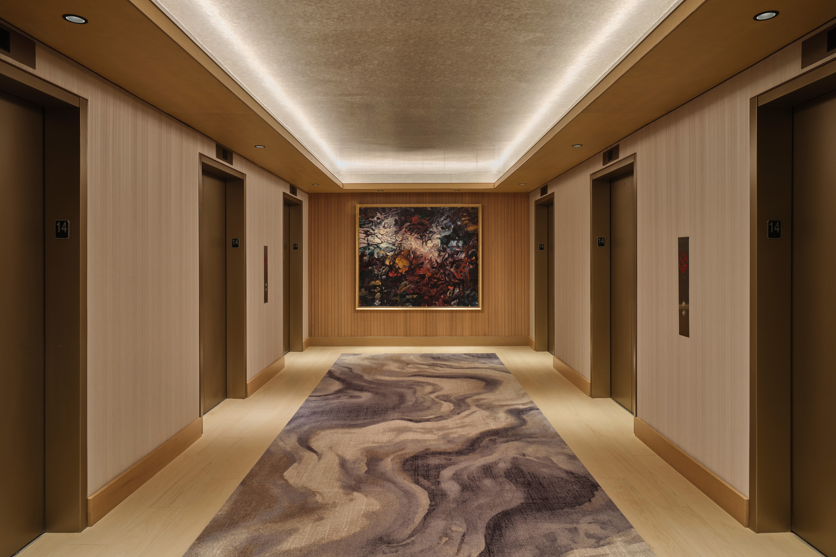 Luxury hotel hallway with contemporary artwork, recessed lighting, and patterned carpet